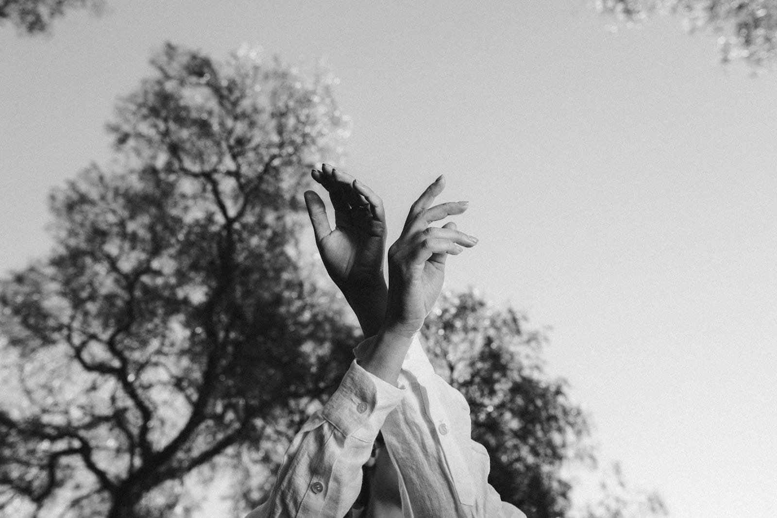 A woman reaching up into the air to catch a frisbee
