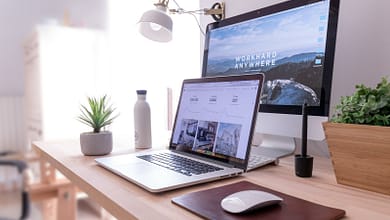 MacBook Pro on table beside white iMac and Magic Mouse