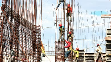 Les défis de la construction durable en Guinée. 2 people working on building during daytime