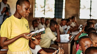 a woman standing in front of a group of children