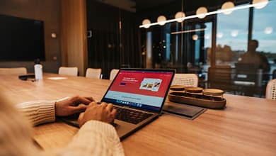 Les défis de l’e-commerce en Guinée. 9 a person sitting at a table with a laptop