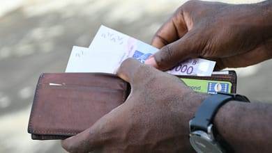 7 sacrifices à faire pour devenir riche rapidement en Afrique. 3 a person holding a pen and a paper with writing on it