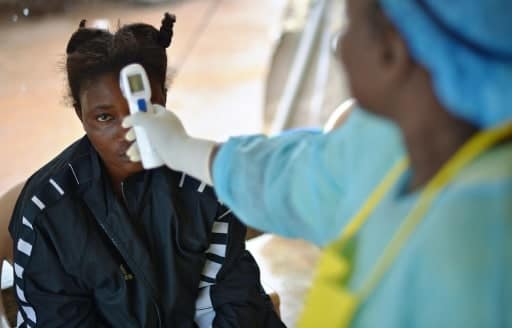 Prise de température d'une petite fille potentiellement porteuse du virus Ebola à Kenema, Sierra Leone, le 16 août 2014 | AFP/Archives | CARL DE SOUZA