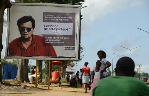 Portrait du journaliste franco-canadien Guy-André Kieffer porté disparu sur un panneau à Abidjan, le 16 avril 2014 | AFP/Archives | ISSOUF SANOGO