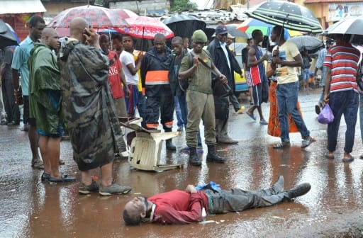 Un homme suspecté d'être mort du virus ebola, gît sur le sol le 21 août 2015 à Conakry | AFP/Archives | CELLOU BINANI