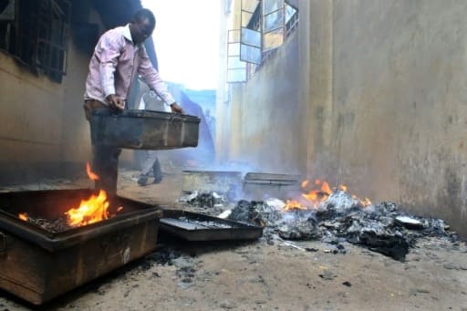 Un étudiant tente de sauver ce qui peut l'être après l'incendie d'une école le 26 juin 2016 dans le district de Kisii | AFP/Archives