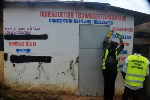 Un employé municipal attribue des numéros aux maisons à Yaoundé, le 9 août 2016 | AFP | Reinnier KAZE