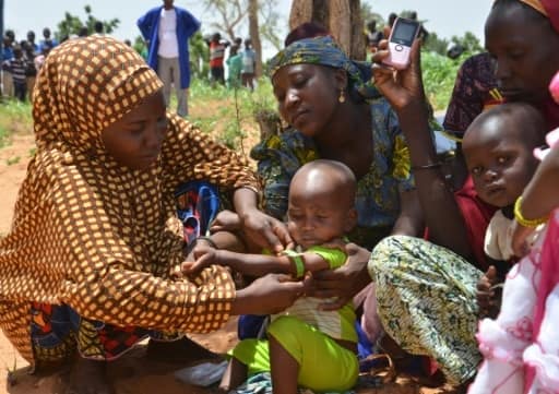 Au Niger, les mères utilisent un périmètre brachial (PB), un brassard tricolore, qui sert à mesurer l'épaisseur du bras et détecter la malnutrition, dans le village de Barago (sud), le 14 juillet 2016 | AFP | BOUREIMA HAMA