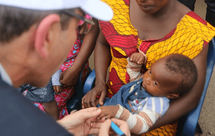 Marc Rubin, Représentant UNICEF, marquant l’auriculaire du petit Ibrahim de 11 mois, après lui avoir administré sa dose de vaccin contre la polio — ©UNICEF/ D-DIARRA