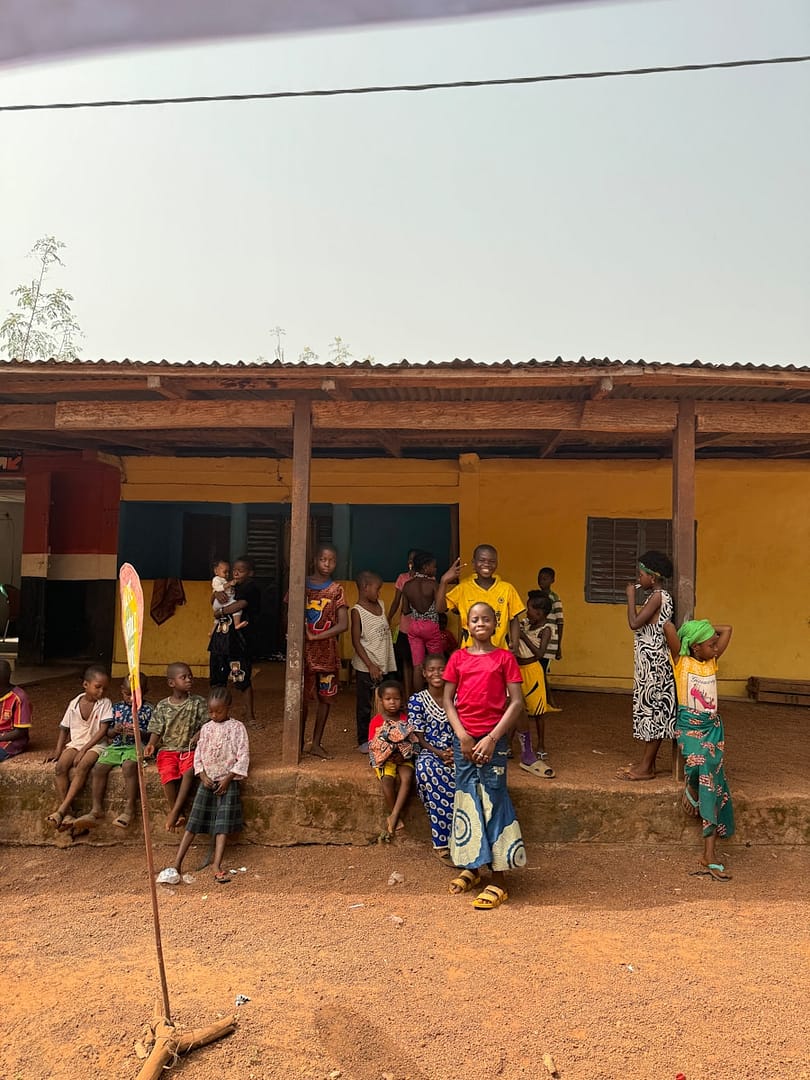A group of people standing in front of a yellow building